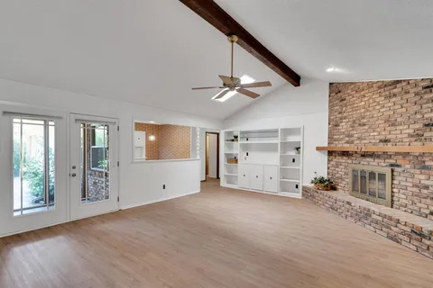 an empty room with windows and fireplace