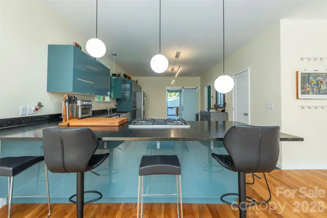 a kitchen with stainless steel appliances granite countertop a stove a sink and a chairs