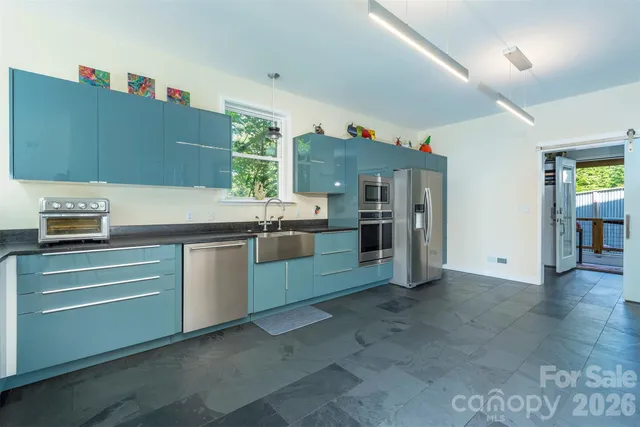 a kitchen with stainless steel appliances cabinets and window