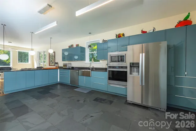 a kitchen with stainless steel appliances granite countertop a refrigerator and a sink