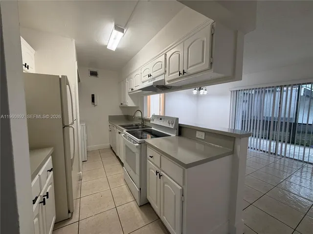 a kitchen with stainless steel appliances granite countertop a sink and a refrigerator