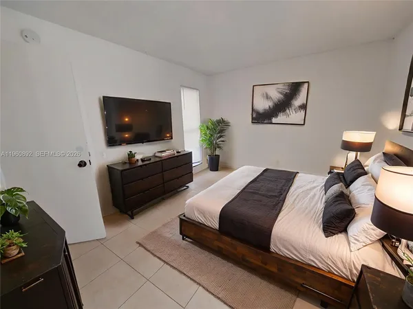 a bedroom with a bed and a flat screen tv