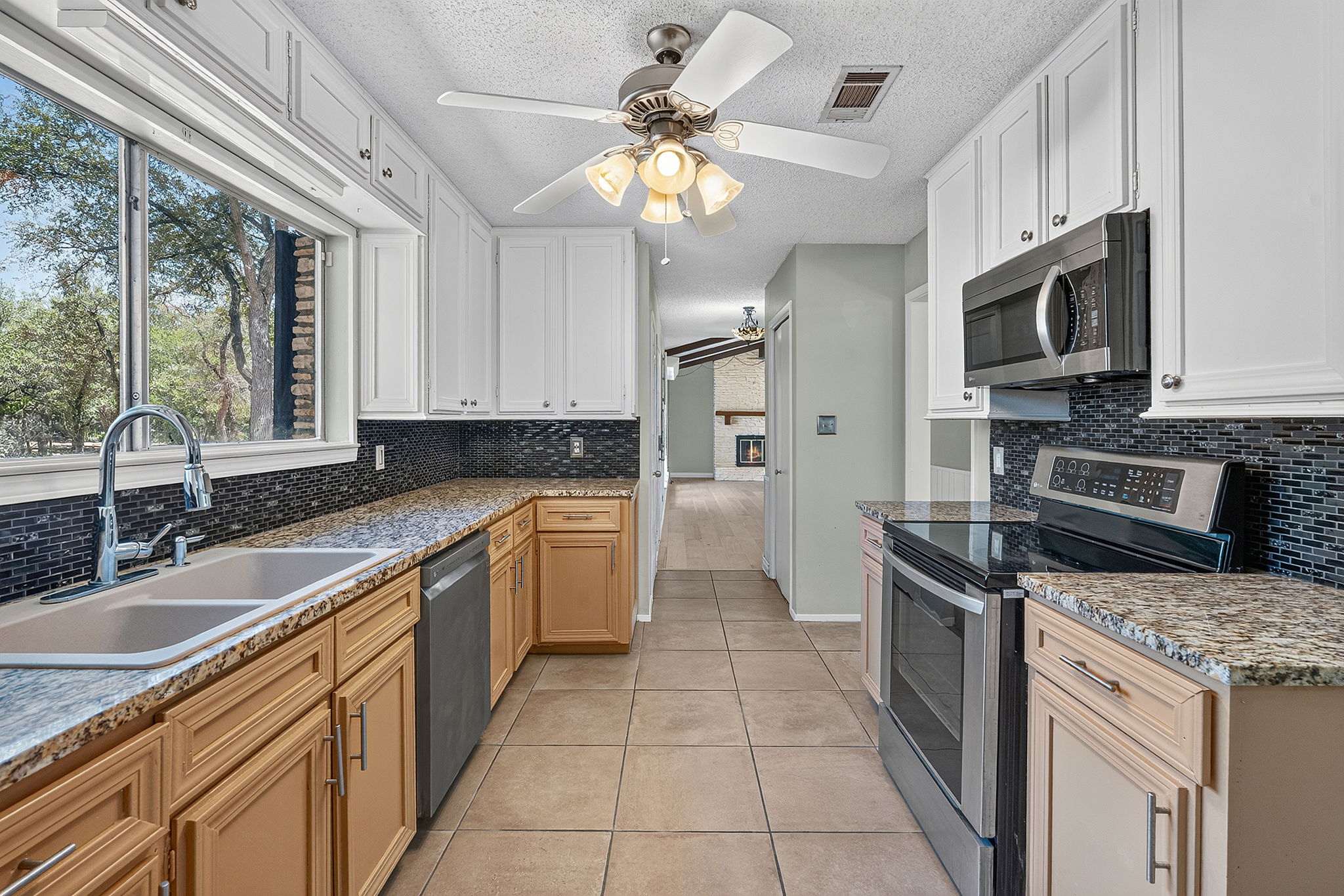 3809 Wyldwood Road Austin, TX 78739 - Photo 13 of 40 Ample counter space and classic cabinetry define this functional, galley-style kitchen layout.