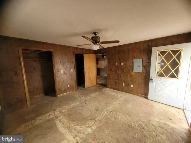 en empty room with a ceiling fan and window
