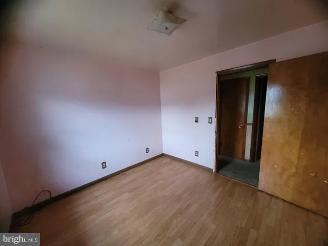 an empty room with wooden floor and closet