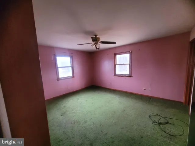 a view of a livingroom with a ceiling fan and window