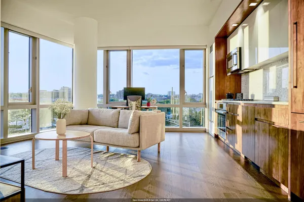 a living room with a couch and a large window with wooden floor