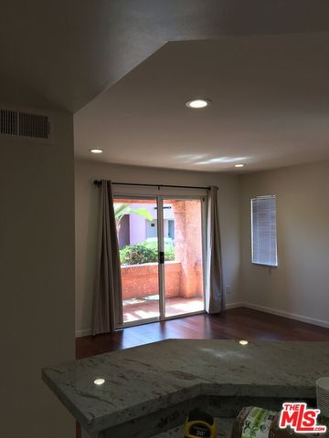 a living room with hardwood floor and large window