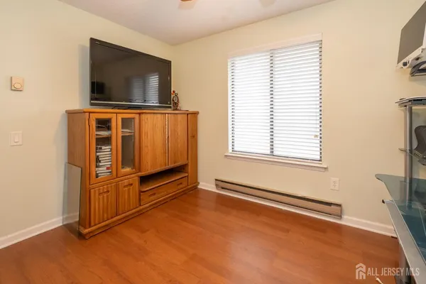 an empty room with windows cabinet and flat screen tv
