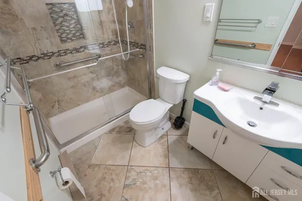 a bathroom with a sink a toilet and shower