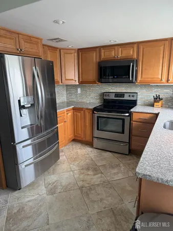 a kitchen with stainless steel appliances granite countertop a refrigerator stove and microwave