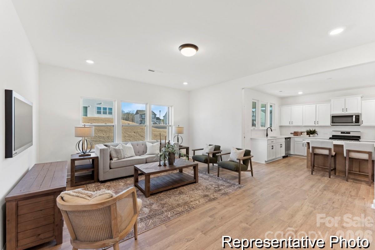 137 Soft Breeze Bend, Unit 283B Locust, NC 28097 - Photo 7 of 21 a living room with furniture and a large window