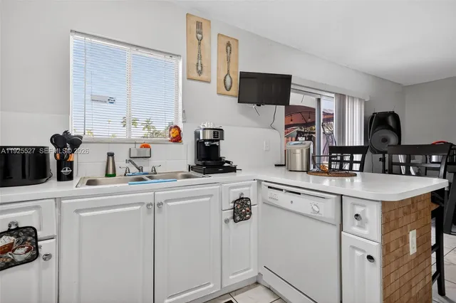 a kitchen with sink a microwave and cabinets