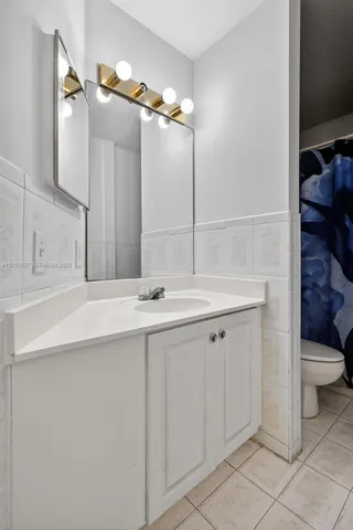 a bathroom with a sink a toilet a large mirror and shower