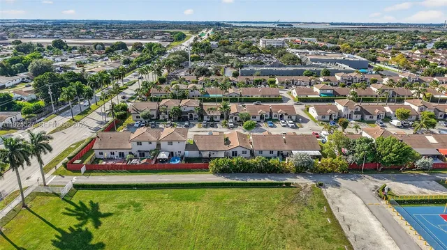 an aerial view of residential houses with outdoor space and swimming pool