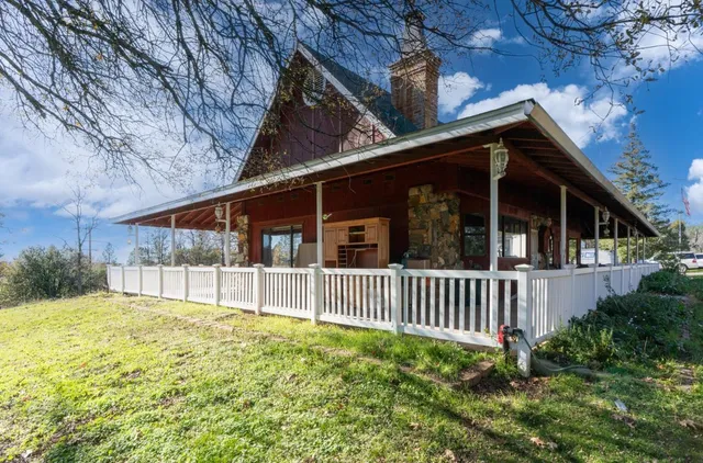 a view of a house with a yard and fence