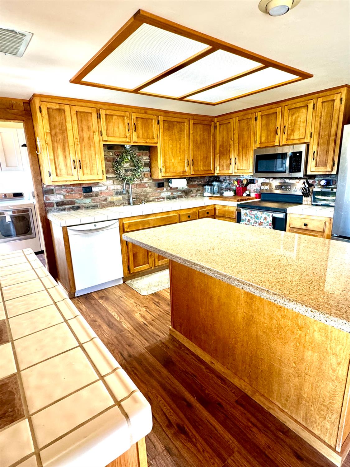 47515 Bissett Station Road Oakhurst, CA 93644 - Photo 41 of 59 a kitchen with stainless steel appliances kitchen island granite countertop a refrigerator and stove