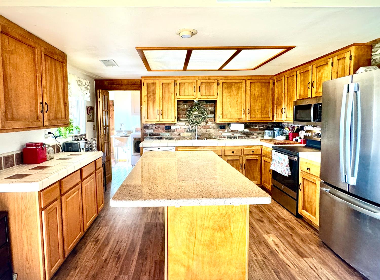 47515 Bissett Station Road Oakhurst, CA 93644 - Photo 42 of 59 a kitchen with stainless steel appliances kitchen island wooden floors and large windows