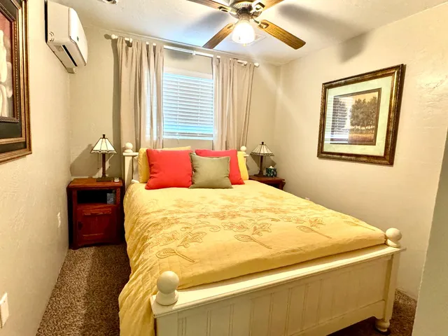 a bedroom with a bed and a painting on the wall