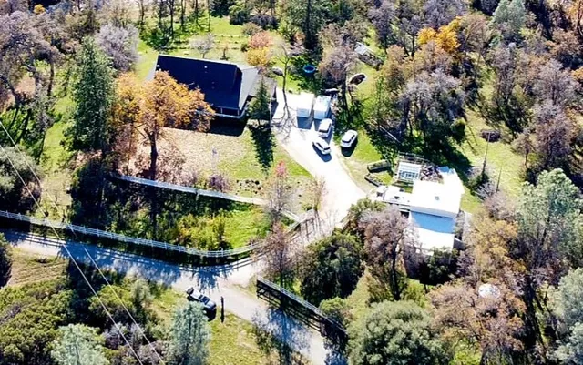an aerial view of a house with a garden and lake view