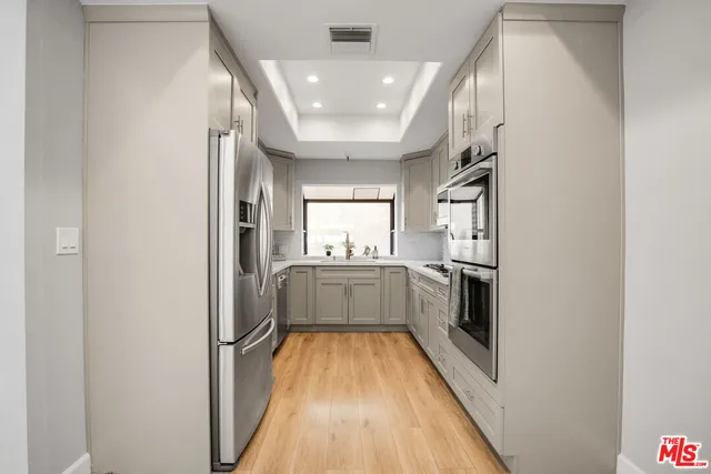 a kitchen with cabinets appliances a sink and a window
