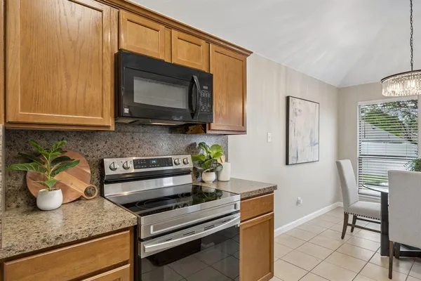 a kitchen with stainless steel appliances granite countertop a stove a microwave and cabinets