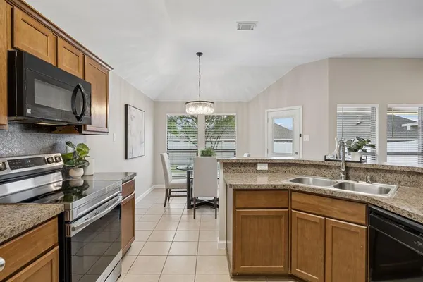 a kitchen with stainless steel appliances granite countertop a sink stove and microwave