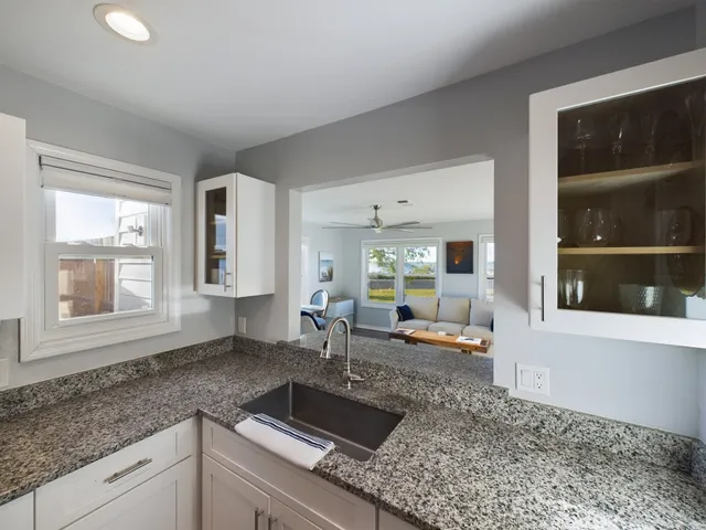 a kitchen with granite countertop sink and cabinets