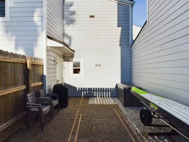 a backyard of a house with barbeque oven table and chairs
