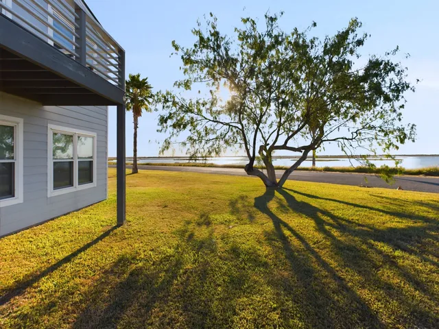 a view of an ocean & house with a yard
