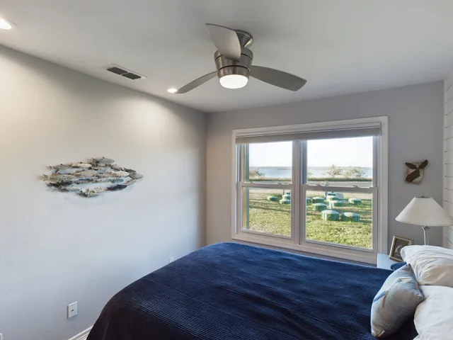 a bedroom with a bed and a large window