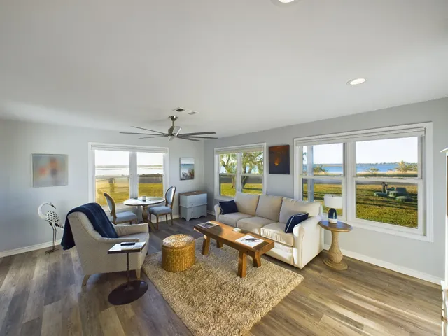 a living room with furniture and floor to ceiling windows