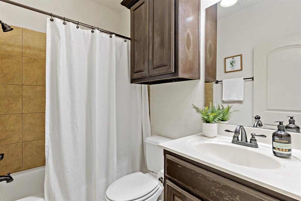 11118 Marion Road, Unit 105 Sanger, TX 76266 - Photo 20 of 29 Bathroom featuring a shower-tub combination with large-format wall tiles, a built-in vanity with a white countertop, an undermount sink, and dark bronze-finish fixtures