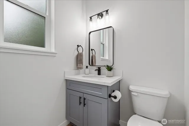 a bathroom with a toilet a sink and mirror