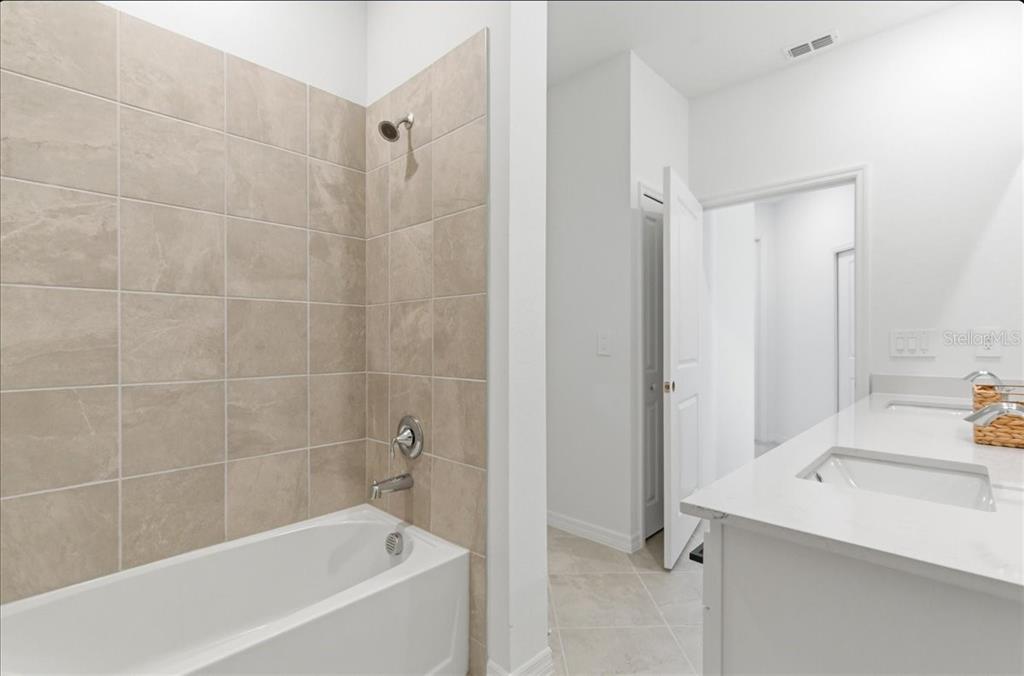 19140 Scallop Loop, Unit 308 Lakewood Ranch, FL 34211 - Photo 15 of 19 a white bath tub sitting next to a bathroom sink