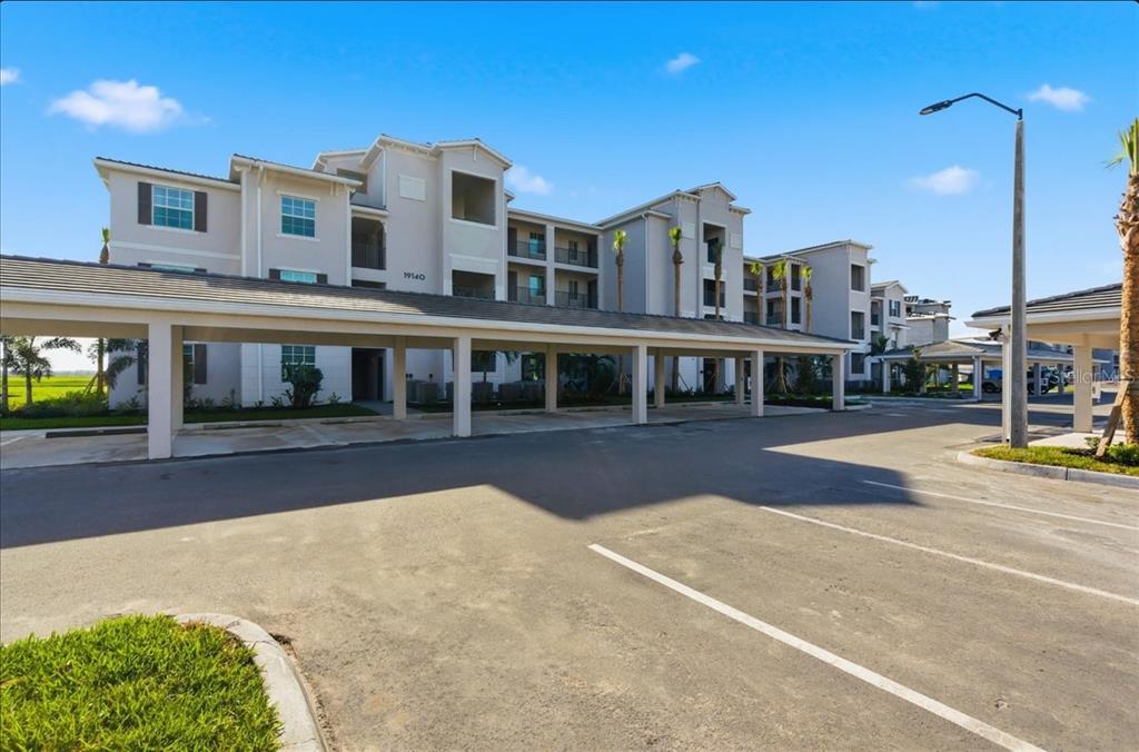 19140 Scallop Loop, Unit 308 Lakewood Ranch, FL 34211 - Photo 16 of 19 a front view of a building with a garden