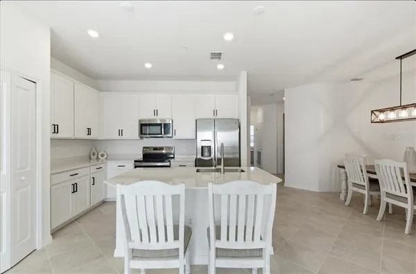 a kitchen with stainless steel appliances kitchen island granite countertop a refrigerator and a stove top oven
