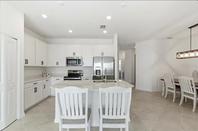 a kitchen with stainless steel appliances kitchen island granite countertop a refrigerator and a stove top oven