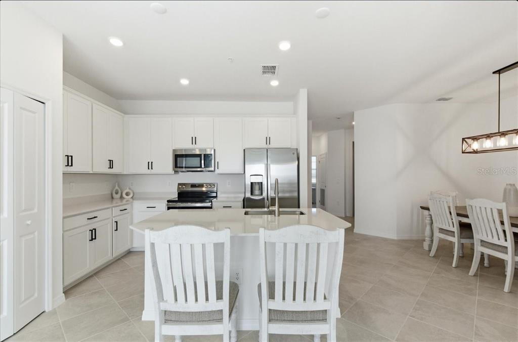19140 Scallop Loop, Unit 308 Lakewood Ranch, FL 34211 - Photo 3 of 19 a kitchen with stainless steel appliances kitchen island granite countertop a refrigerator and a stove top oven