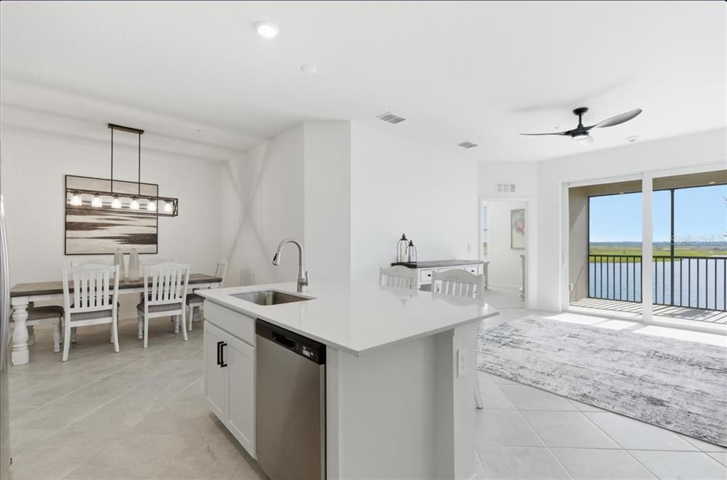19140 Scallop Loop, Unit 308 Lakewood Ranch, FL 34211 - Photo 5 of 19 a dining hall with stainless steel appliances kitchen island a table and chairs