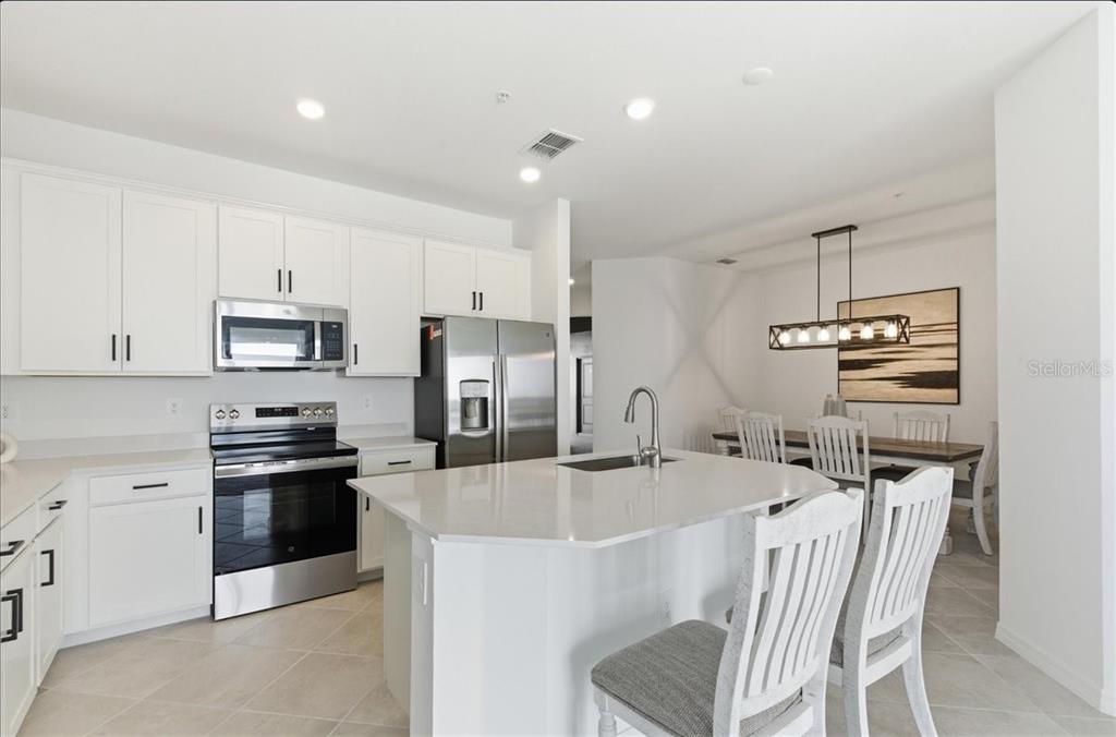 19140 Scallop Loop, Unit 308 Lakewood Ranch, FL 34211 - Photo 6 of 19 a kitchen with stainless steel appliances a sink stove and refrigerator