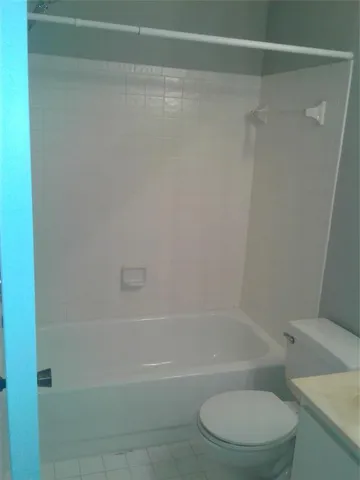 a white bath tub sitting next to a toilet