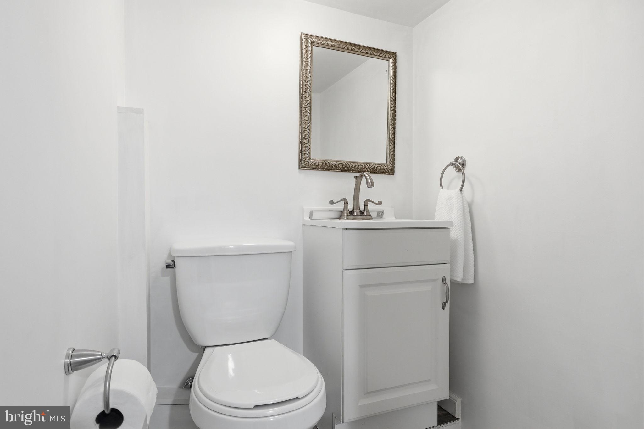 7601 Hollins Road Henrico, VA 23229 - Photo 28 of 47 a bathroom with a toilet sink and mirror