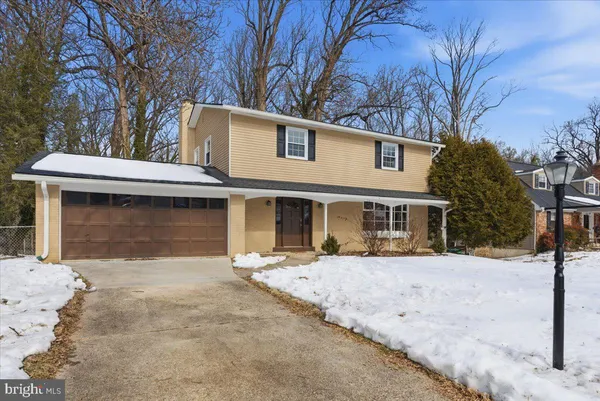 a view of a white house with a large tree
