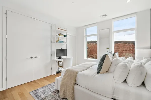 a bedroom with a bed and wooden floor