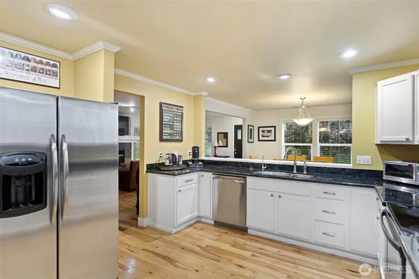 a kitchen with stainless steel appliances kitchen island granite countertop a sink and cabinets