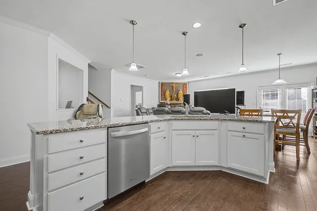 a kitchen with granite countertop white cabinets and stainless steel appliances