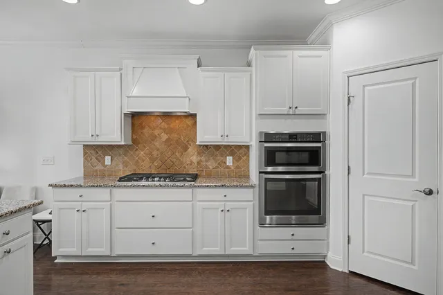 a living room with stainless steel appliances furniture and a flat screen tv