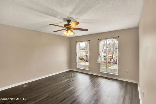 an empty room with wooden floor and window