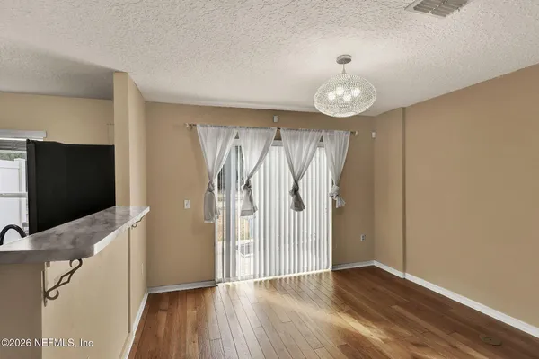 a view of a livingroom with wooden floor and a ceiling fan